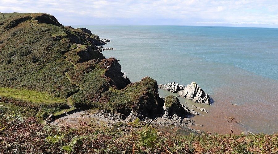 Cliff-top coastal path overlooking rocky shoreline and calm sea